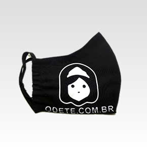 Máscara Preta em algodão com a logo da odete na parte esquerda da bocheca na cor branca e abaixo da logo escrito odete.com.br em letra minúscula